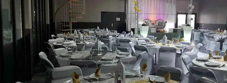 Salle de réception décorée avec tables nappées et estrade lumineuse