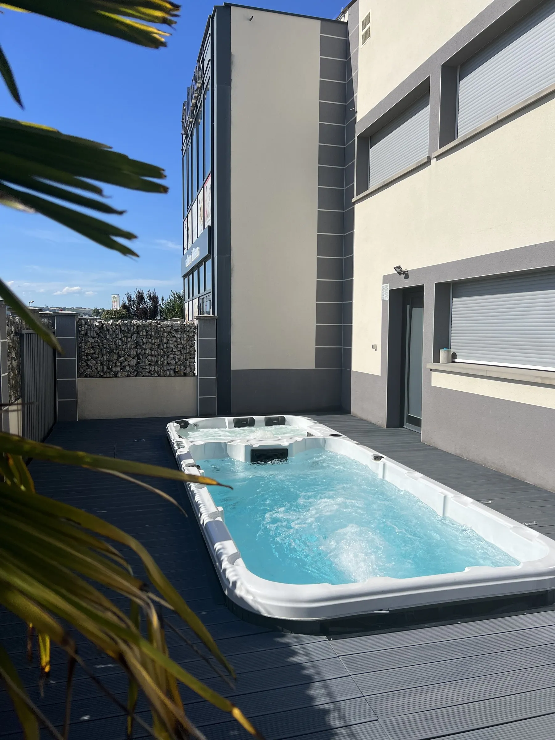 Jacuzzi extérieur sur la terrasse en bois, au soleil